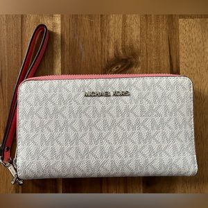 White logo Michael Kors zip up wallet with peachy pink accent.